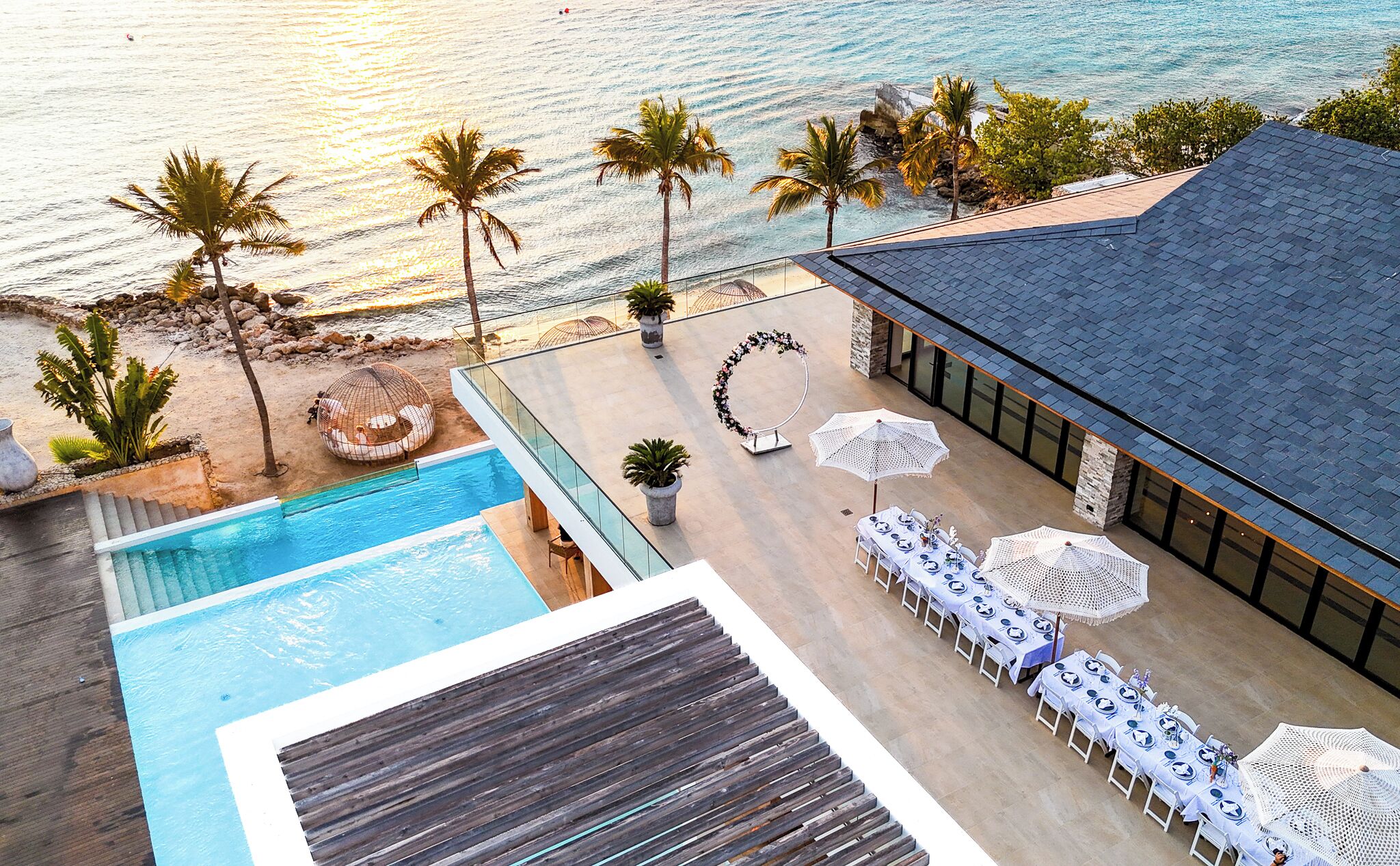 Un resort con piscina, mobiliario exterior y vista al océano.