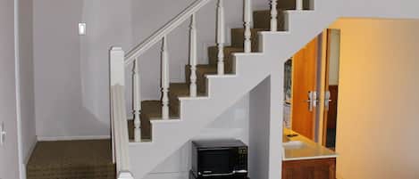 A staircase with white railings and a carpeted landing area.
