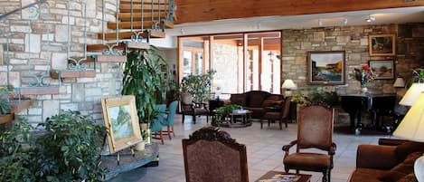 A spacious living area with a stone wall, wooden staircase, and comfortable seating.