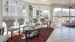 A hotel lobby with a seating area, large windows, and a view of the outside. - Pacifica Beach Hotel (Pacifica)