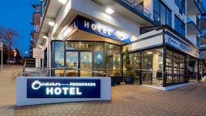 The Ocean Promenade Hotel with a modern facade, large glass windows, and a signboard.