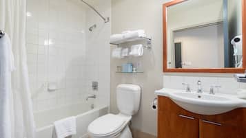 Un baño con ducha, inodoro, lavamanos y espejo.