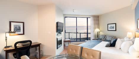 Una habitación de hotel con cama, escritorio, silla y una mesa de vidrio.
