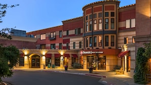 Un hôtel à la façade incurvée, doté de plusieurs entrées et d’une enseigne bien visible indiquant « Premier Best Western ».
