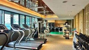 Ein Fitnessstudio mit Laufbändern, Crosstrainern und Kurzhanteln.