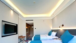 Ein Hotelzimmer mit einem Bett, einem Fernseher, einem Schreibtisch und einem begehbaren Kleiderschrank.