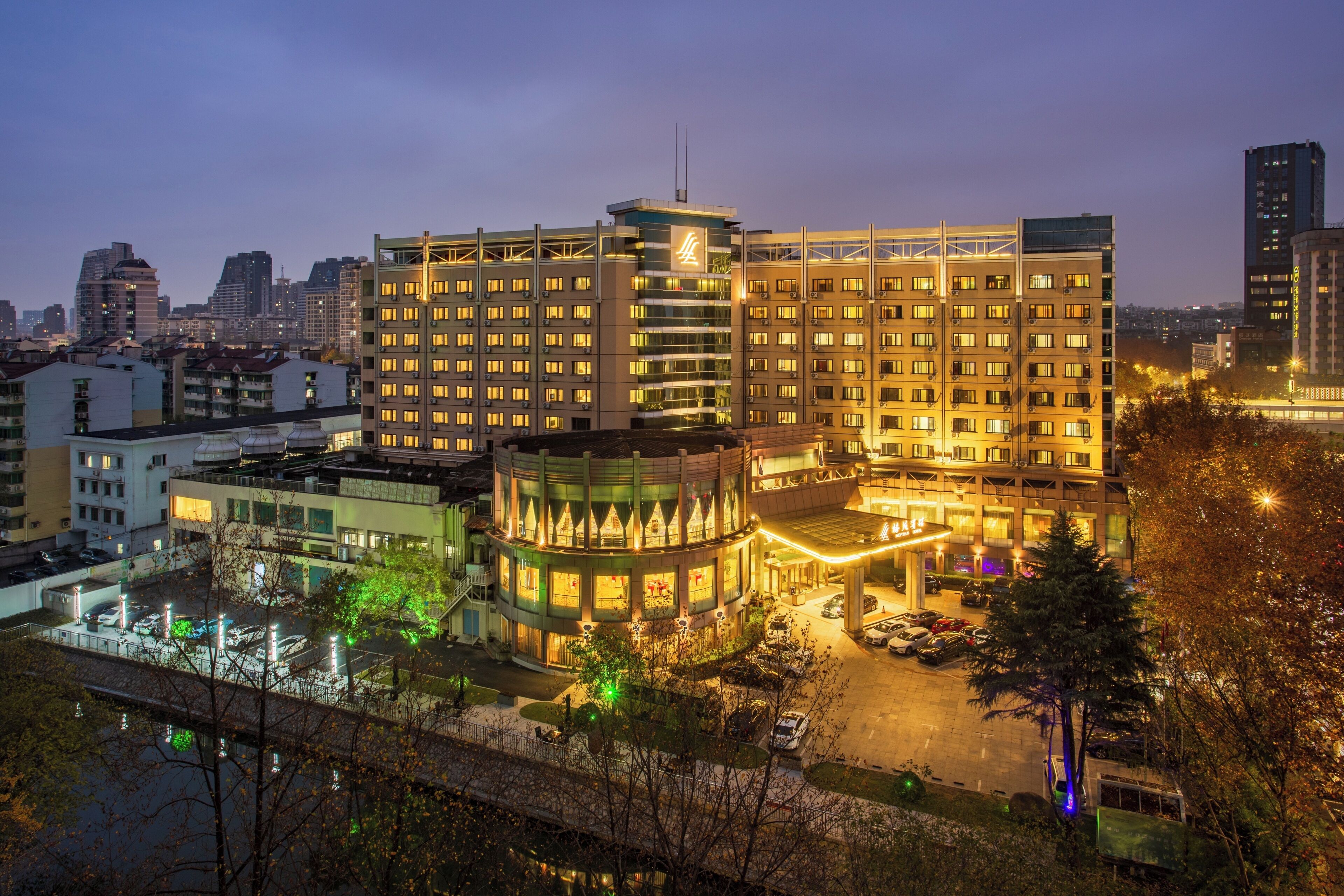 Un hotel de varios pisos con un atrio central, varios balcones y un estacionamiento.