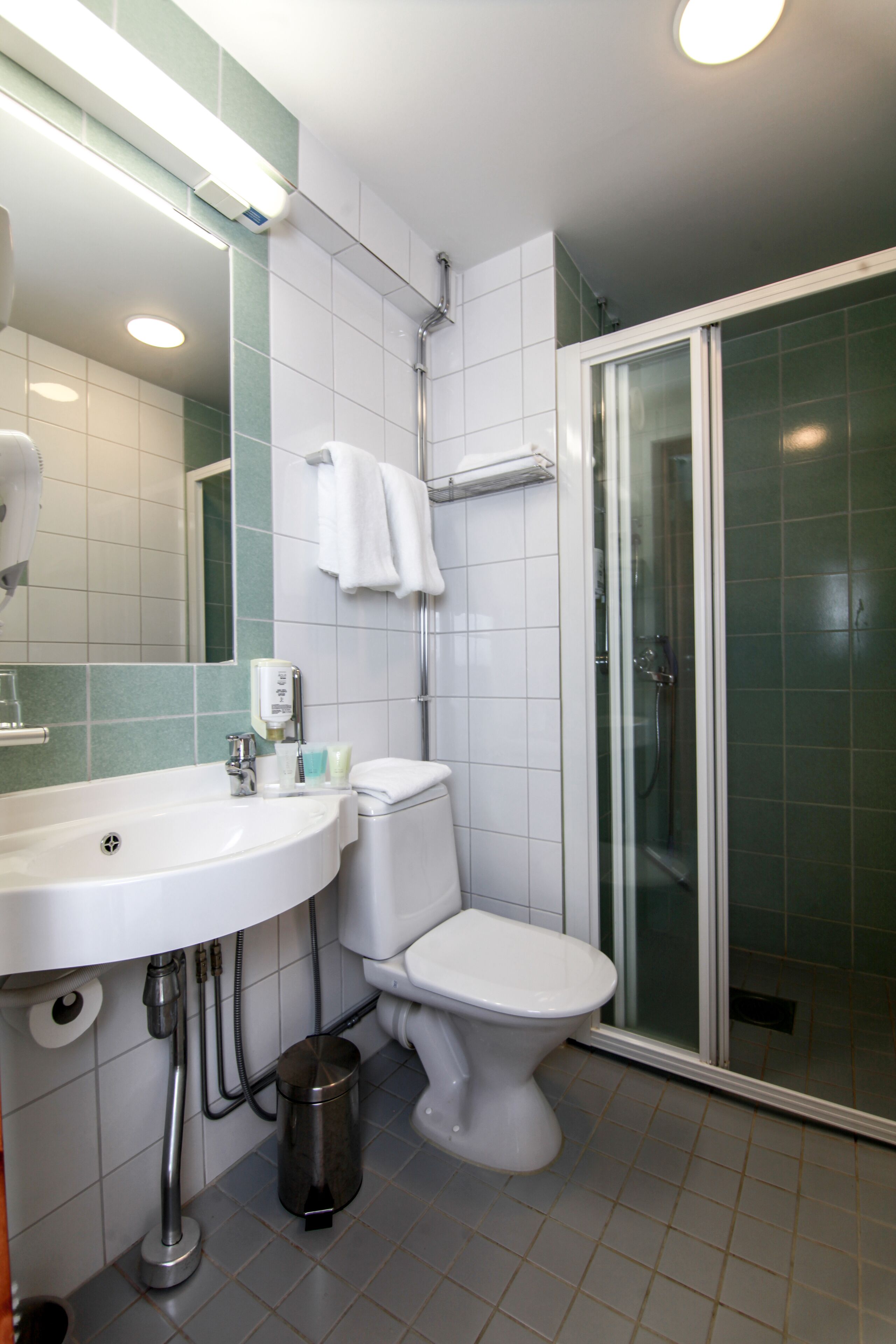 A bathroom with a sink, toilet, and shower.