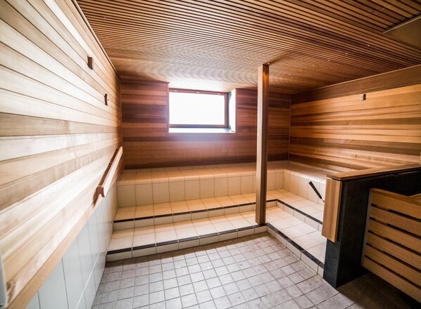 Un sauna avec des murs en bois et un plafond incliné.