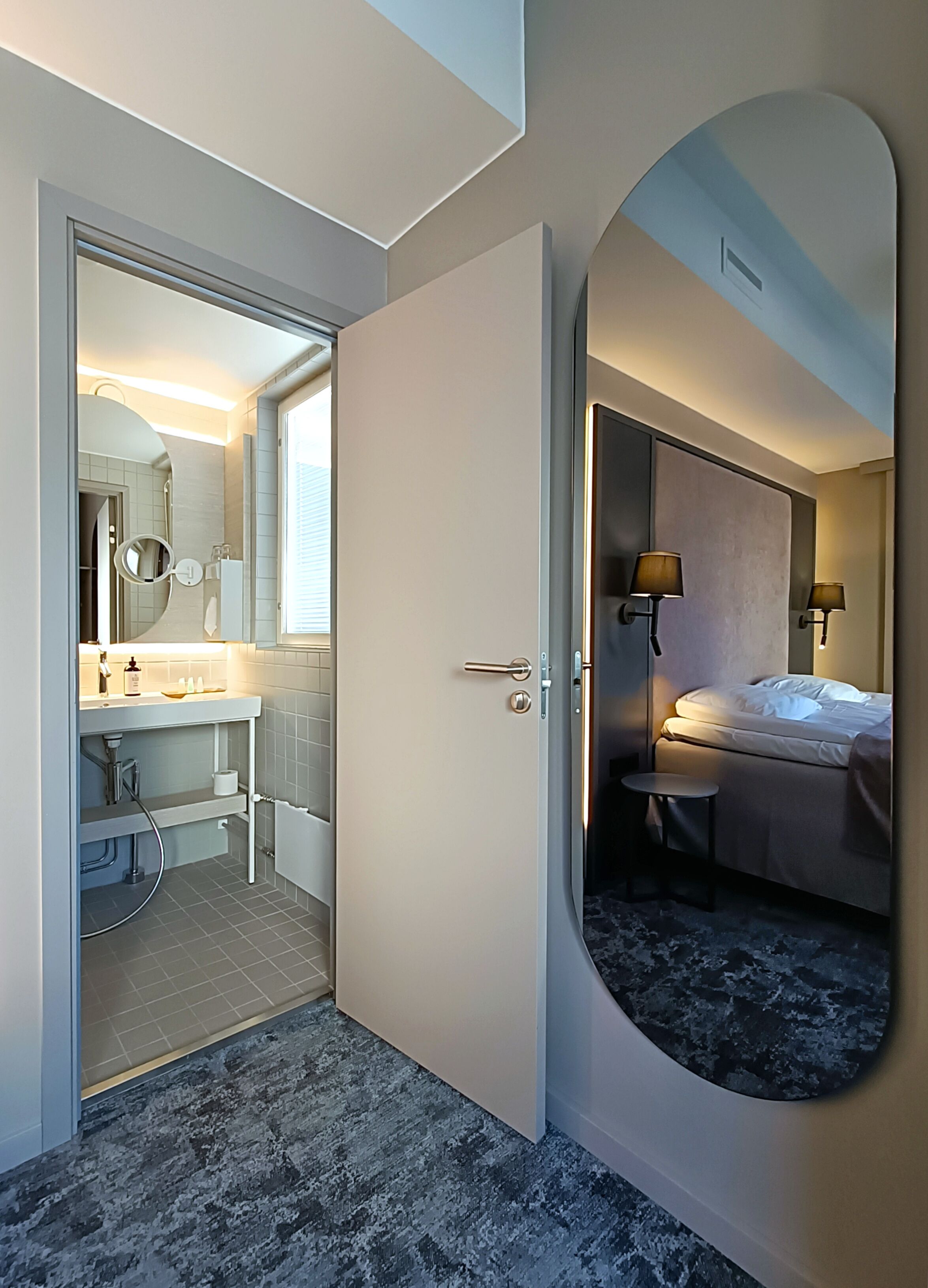 Ein Hotelzimmer mit Bad, Bett und einem großen Spiegel.