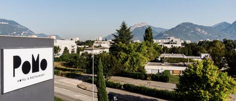 Señal de hotel que dice 'Polo Hotel & Restaurant' y vista de un paisaje urbano con montañas al fondo.