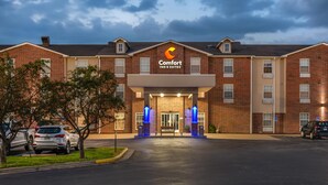 Un edificio de ladrillo con un letrero que dice "Comfort Inn & Suites".