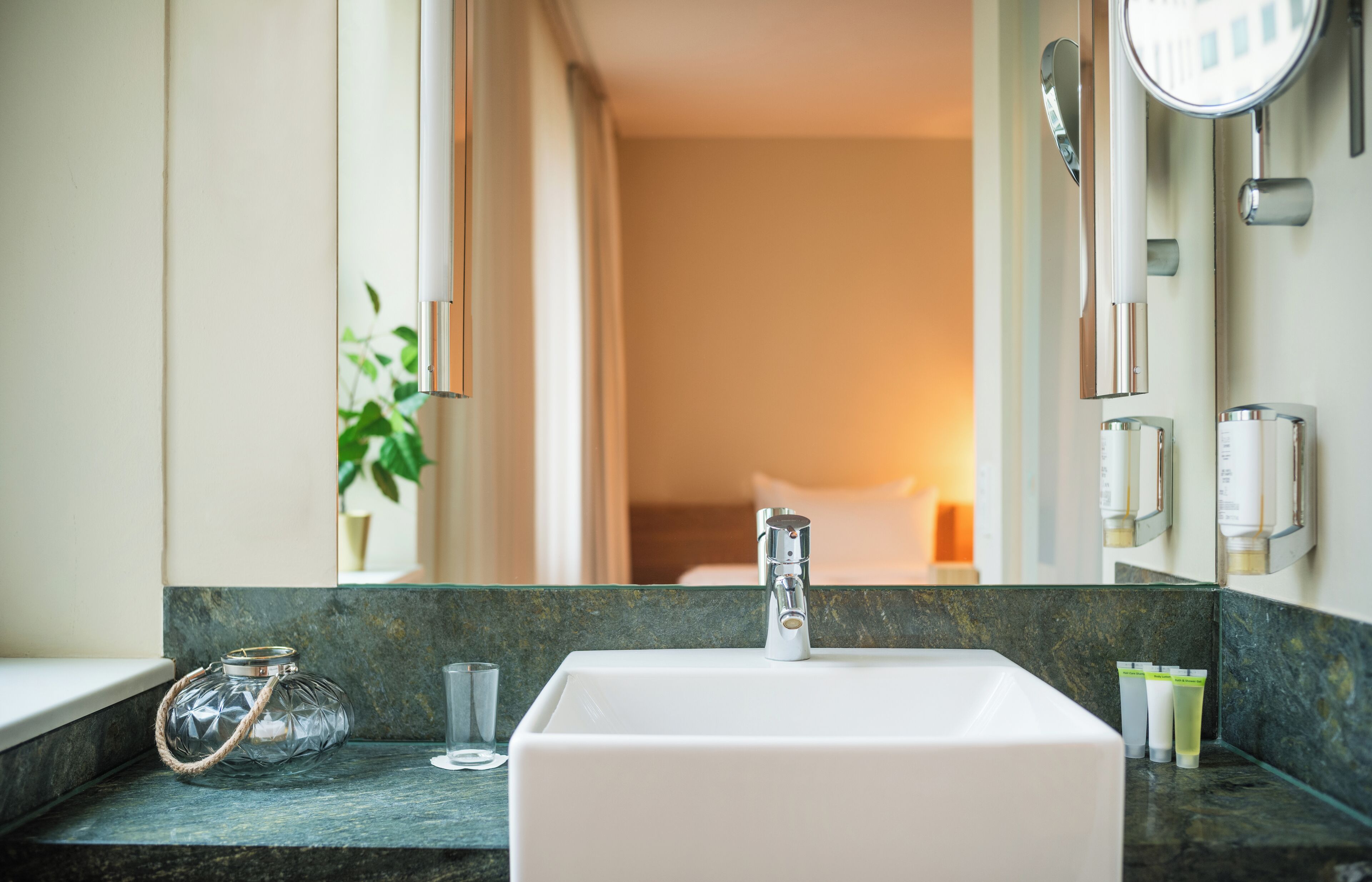 A bathroom with a white sink, a glass jar, and toiletries on the counter.
