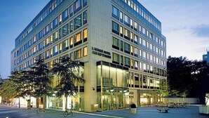 A modern hotel building with multiple floors, large windows, and a well-lit entrance. - Lindner Hotel Berlin Ku’damm, part of JdV by Hyatt (Berlin)