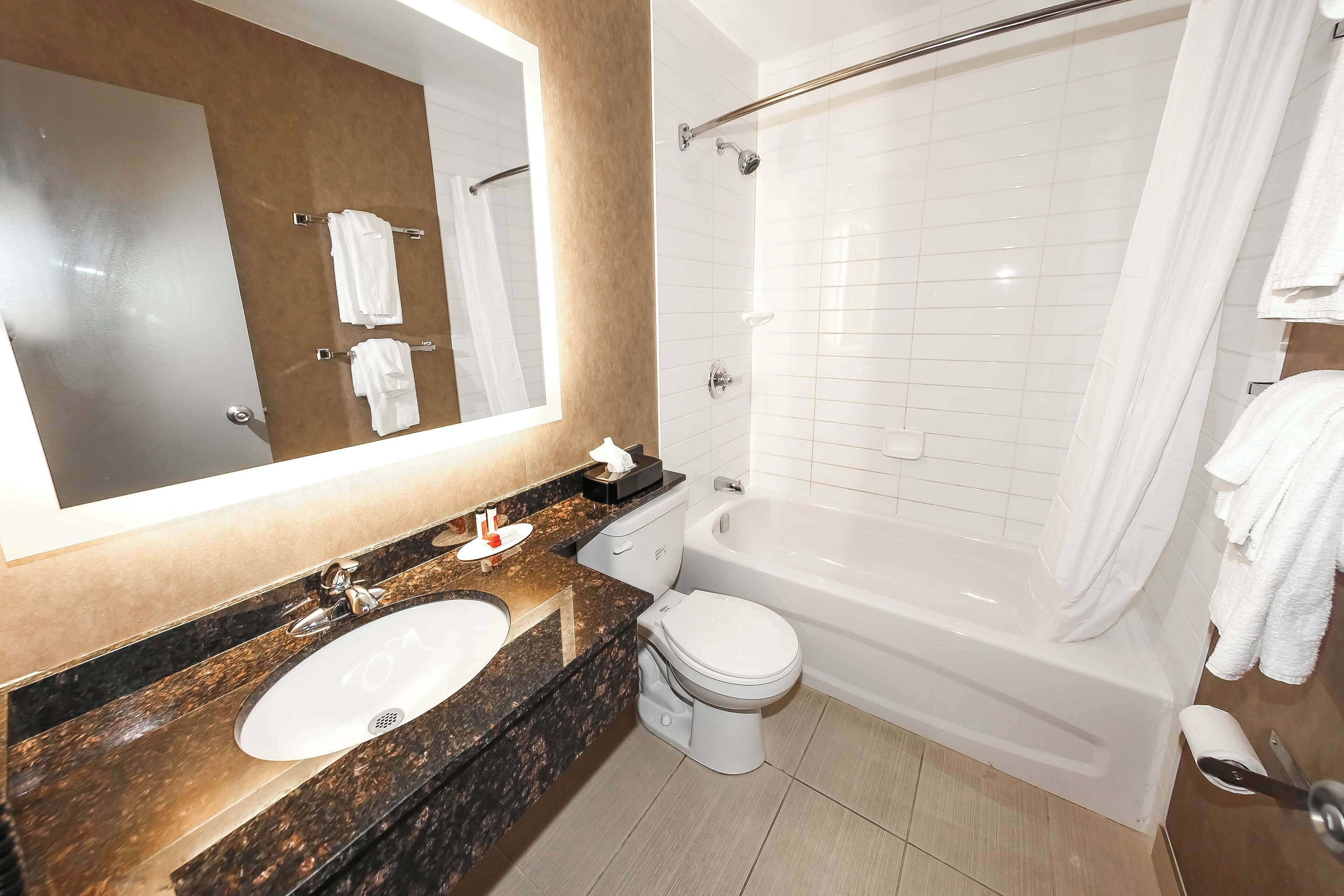 Un baño moderno con lavamanos, inodoro y bañera.