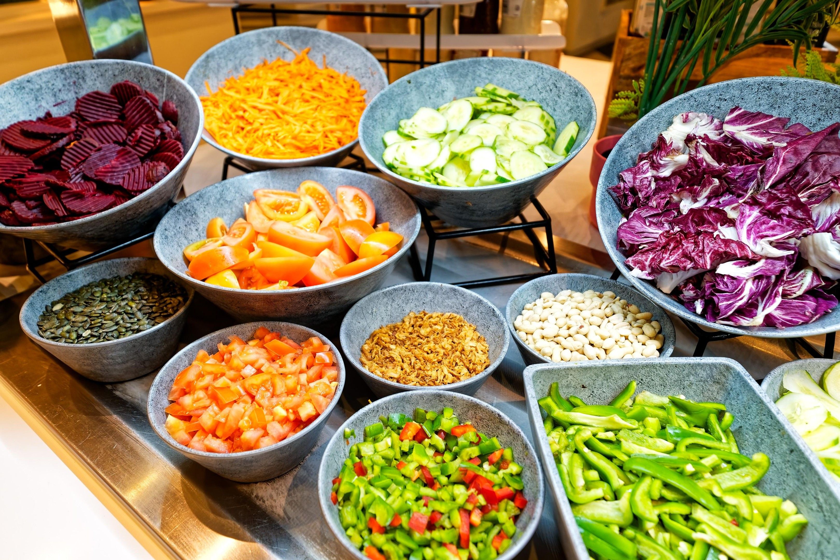 Una mesa de buffet con diferentes alimentos servidos en recipientes.