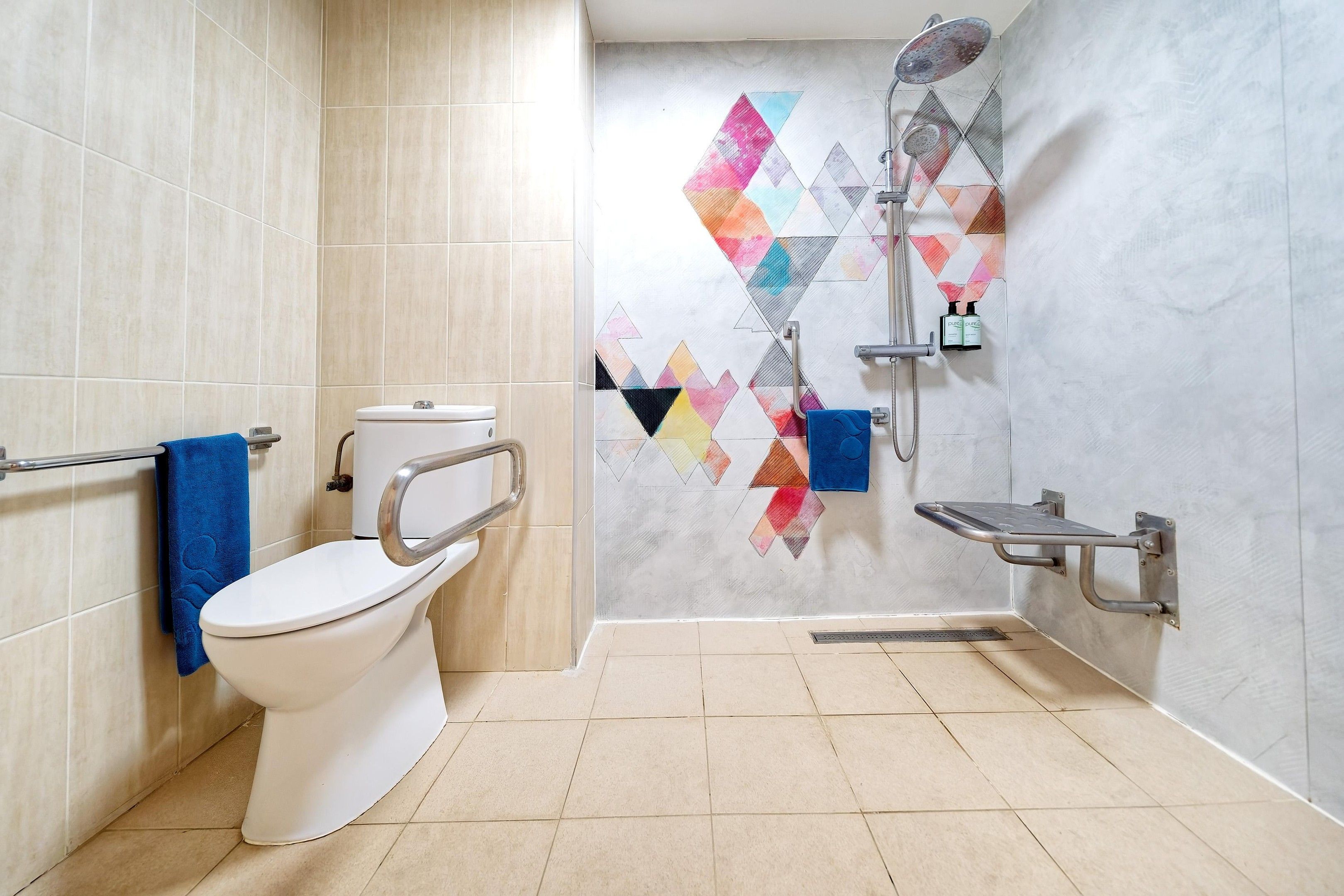 Un baño moderno con inodoro, ducha y barandilla.