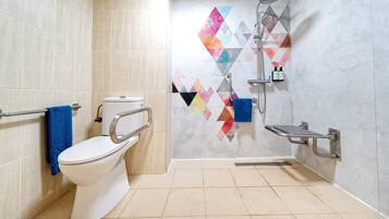 Un baño moderno con inodoro, ducha y barandilla.