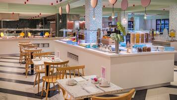 A buffet area with a central island, wooden tables, and chairs.