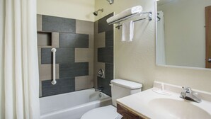 A bathroom with a bathtub, toilet, and sink.
