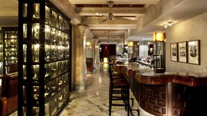 A bar area with a glass display case, wooden bar counter, and seating.