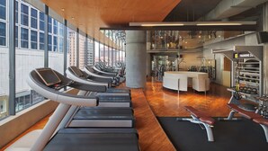 A modern gym with treadmills, weight machines, and a reception area.
