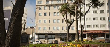 Un hotel con un cartel que dice "HOTEL IRUÑA" y una estatua al frente.