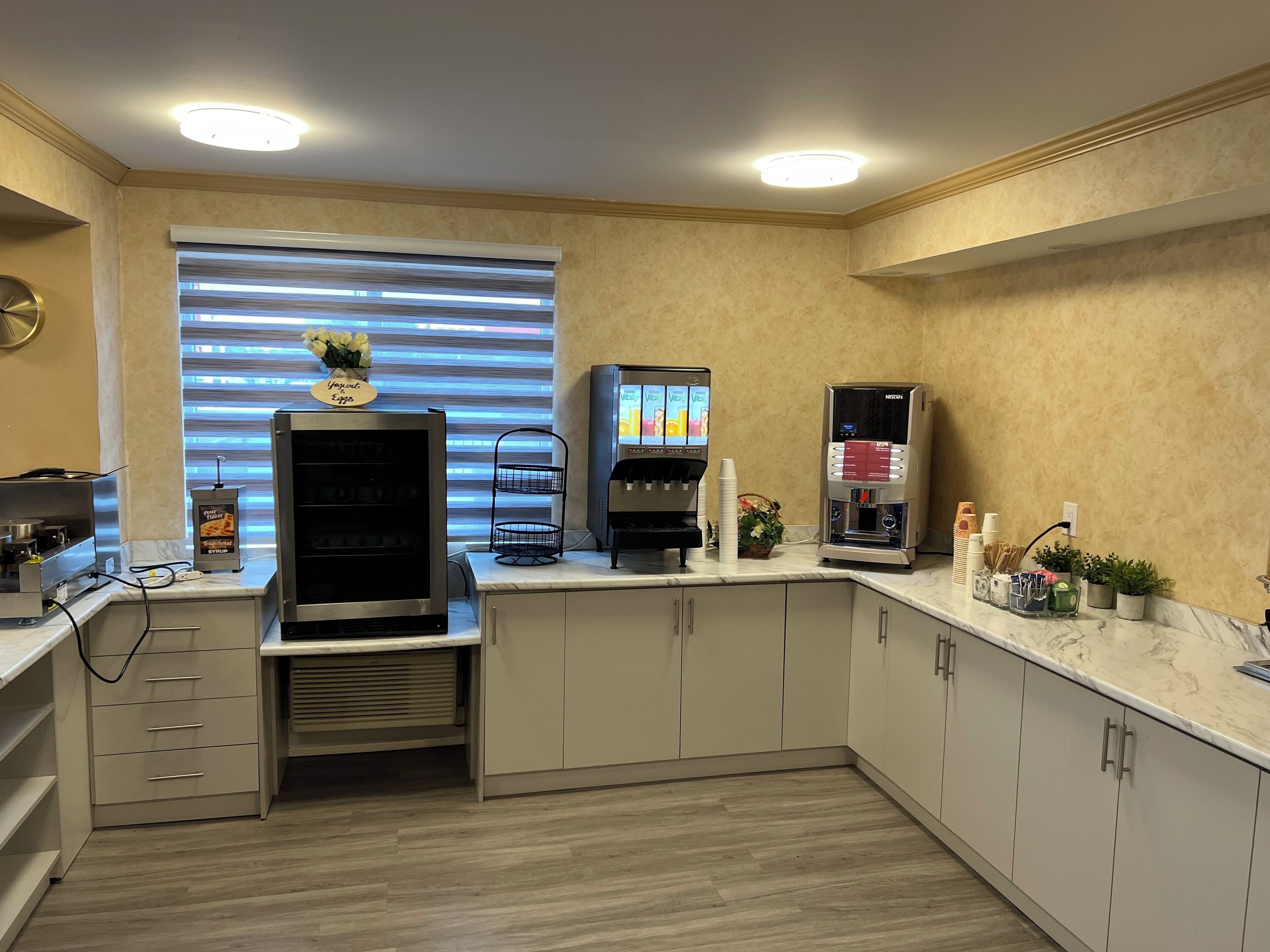 A modern kitchen with a built-in espresso machine, a yogurt dispenser, and a coffee machine.