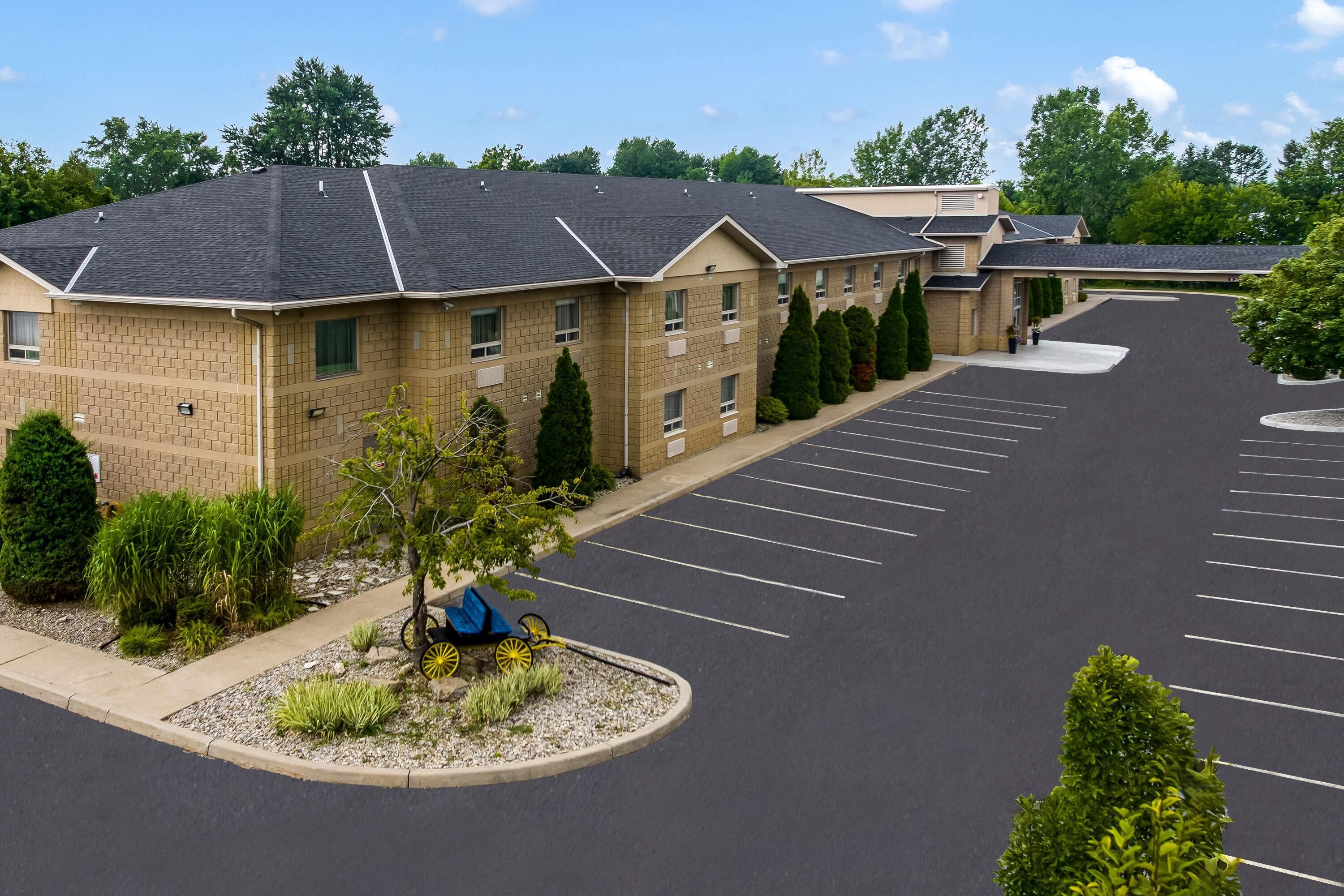 A multi-story hotel with a parking lot and landscaping.