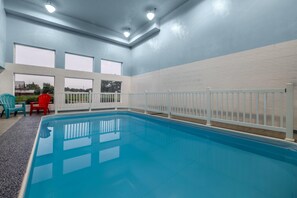 An indoor swimming pool with a white fence, large windows, and a view of the outside. - Days Inn by Wyndham Leamington (Leamington)