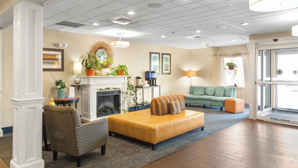 A spacious lobby with a fireplace, comfortable seating, and a view of the outdoors. - Holiday Inn Express Ludlow by IHG (Ludlow)