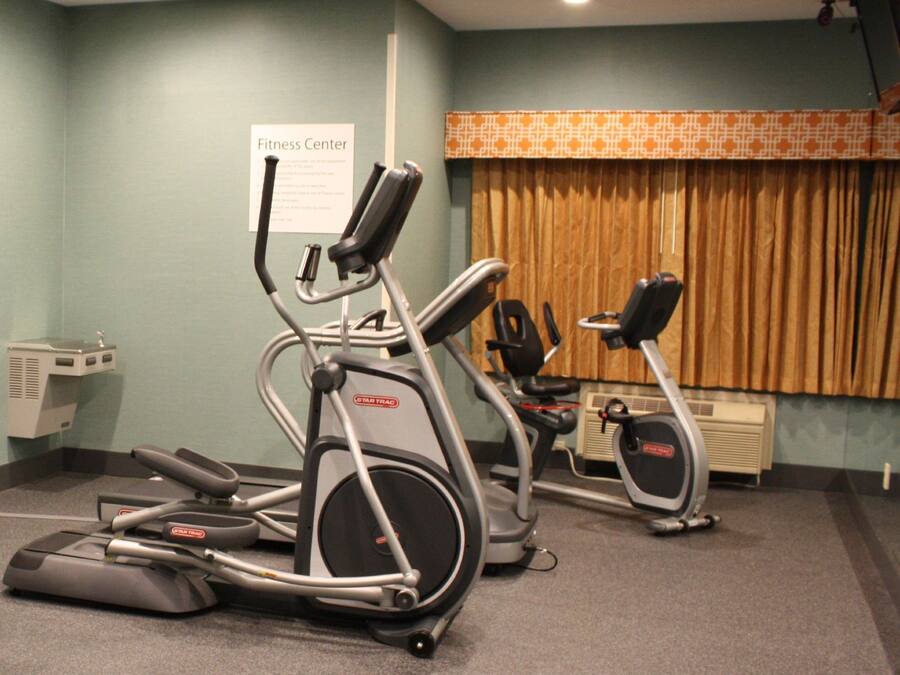 A fitness center with two treadmills and a stationary bike.