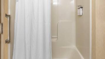 Un baño con ducha, inodoro y toallero.