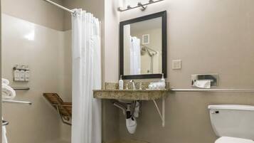 Un baño con ducha, inodoro, lavamanos y espejo.