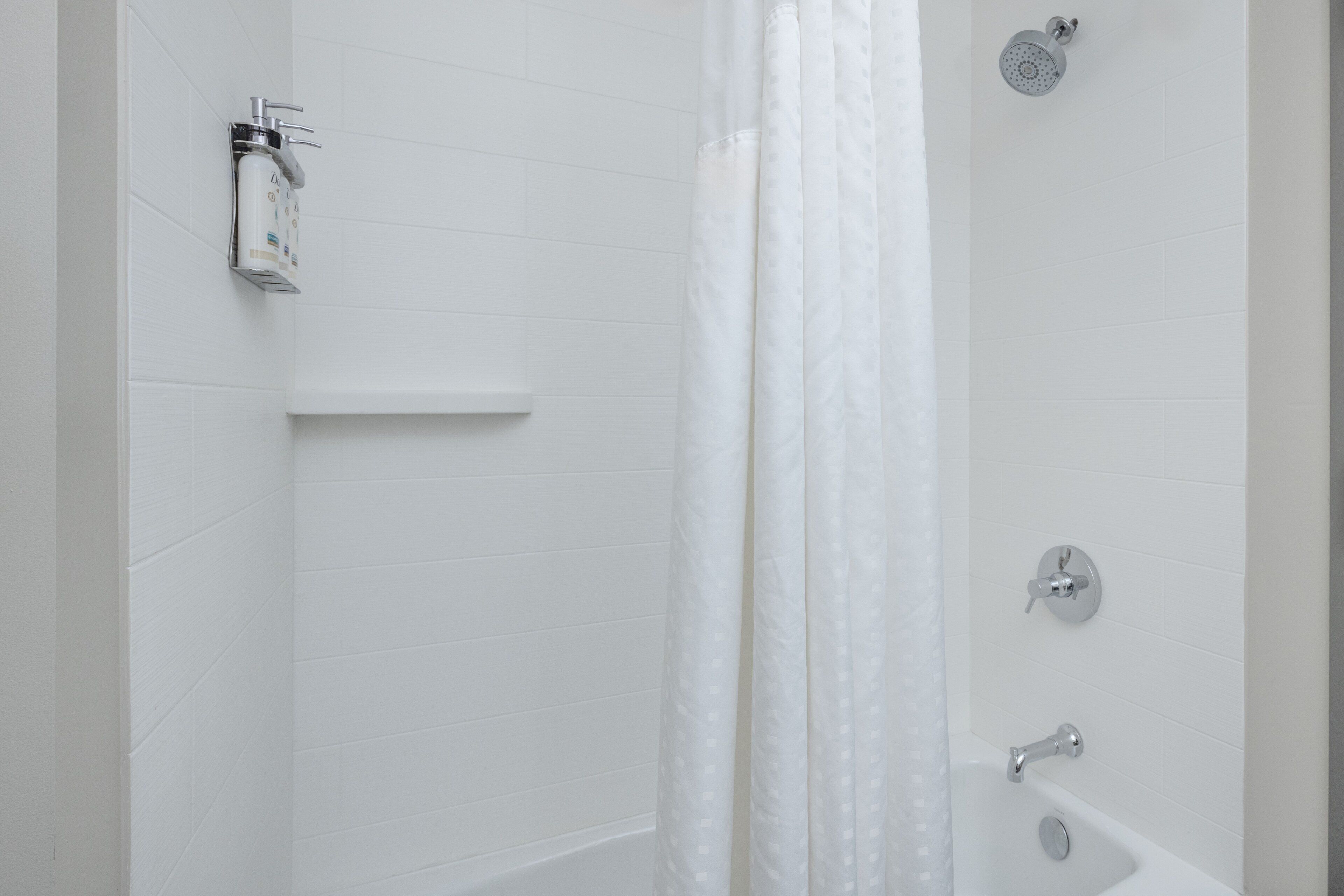 Een badkamer met een douche, wastafel en toilet.
