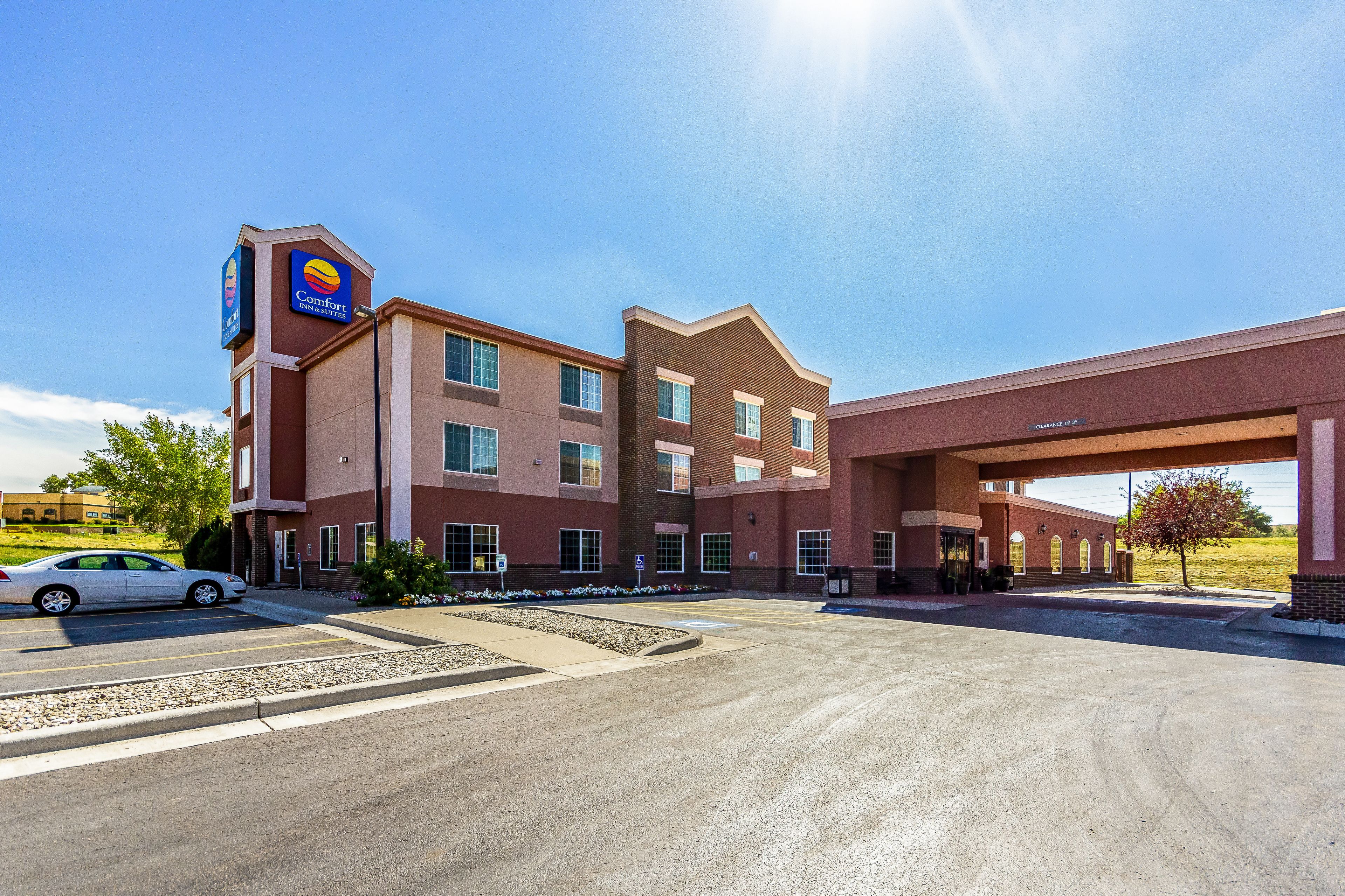 A Comfort Inn hotel with a parking lot and a gas station canopy.