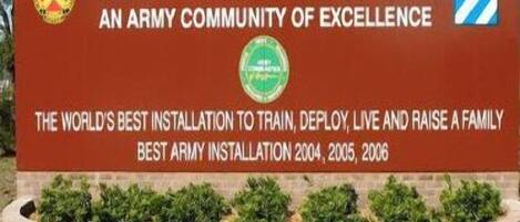 A sign welcoming visitors to Fort Stewart, Georgia, highlighting it as an army community and a top installation for training, deploying, and living.