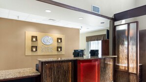 A hotel reception area with a modern design, featuring a reception desk, a sign for 'Comfort Suites', and a view of the interior. - Comfort Suites Odessa near University (Odessa)
