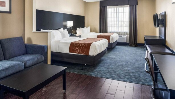 A hotel room with two beds, a sofa, a desk, a TV, and a window with curtains. - Comfort Suites Odessa near University (Odessa)