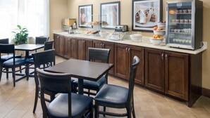 A breakfast area with a counter, seating, and a refrigerator. - Comfort Suites Odessa near University (Odessa)