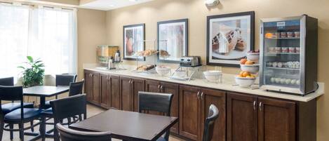 A breakfast area with a counter, seating, and a refrigerator.