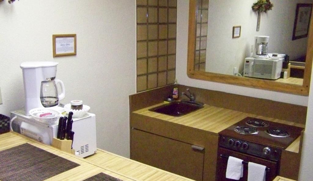 Una kitchenette compacta con cafetera, microondas, pileta y cocina.