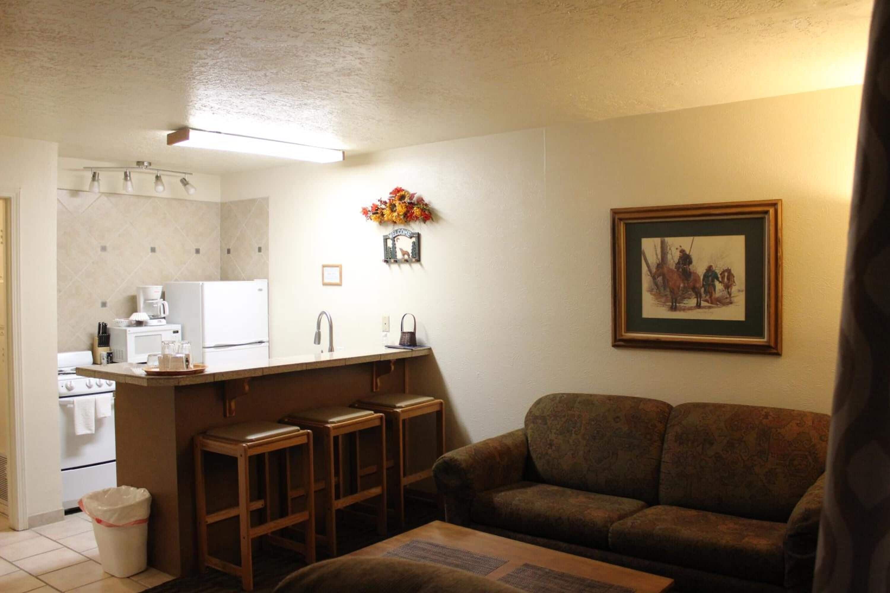 A compact living space with a kitchenette, a sofa, and a dining area.