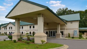 A hotel with a covered entrance, multiple floors, and a parking lot. - Star City Inn & Suites (Star City)