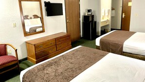 A hotel room with two beds, a dresser, a mirror, a television, and a coffee maker. - Star City Inn & Suites (Star City)