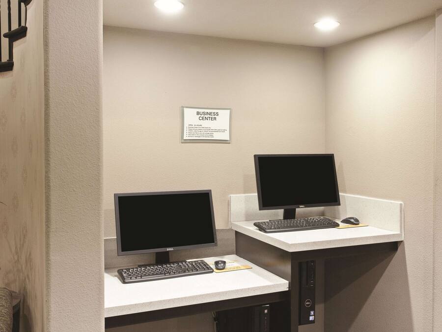 Un centre d’affaires équipé de deux postes de travail informatiques, chacun comprenant un écran, un clavier et une souris.