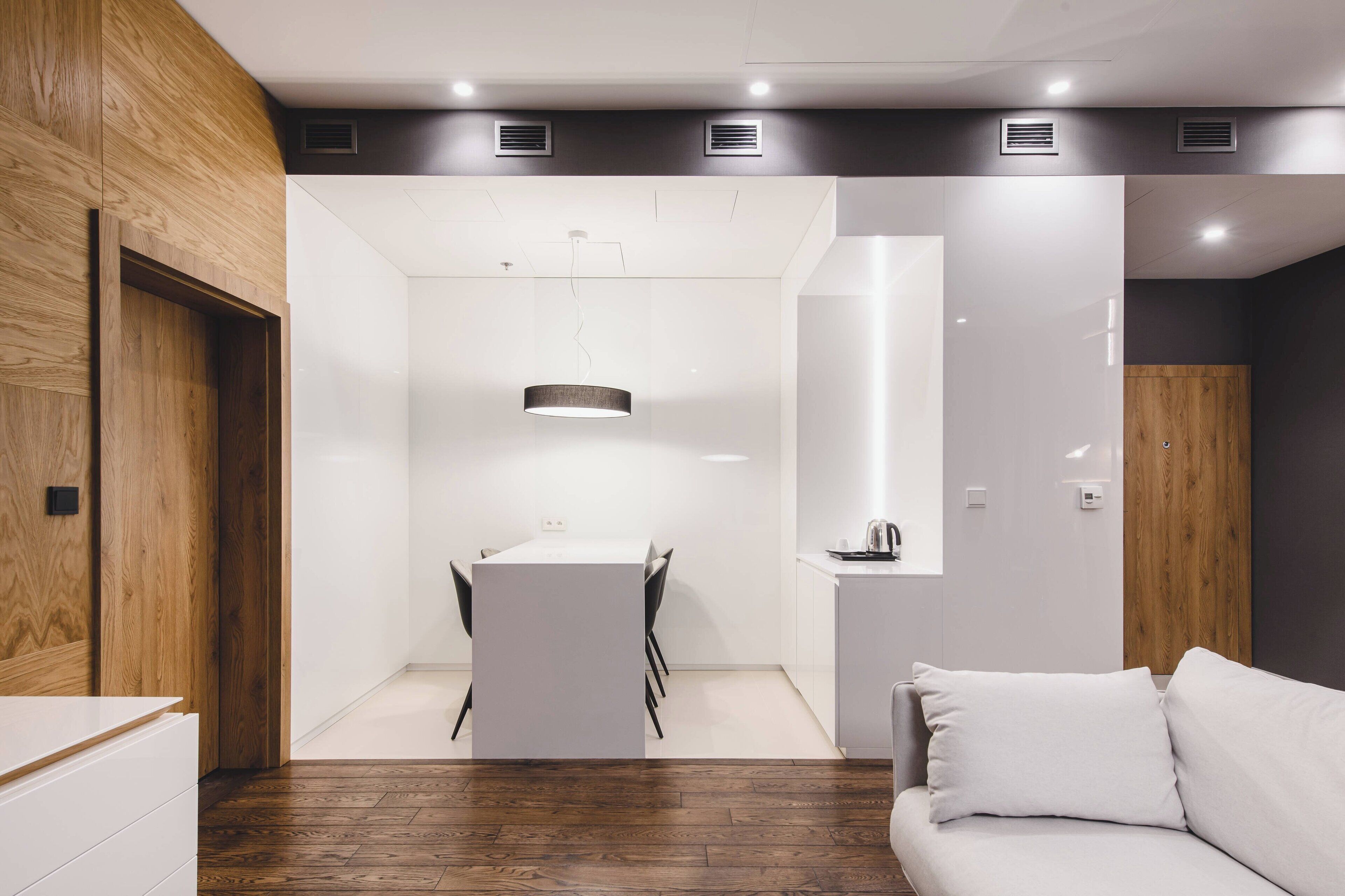 Een modern interieur met een eethoek, een bank en een wand van hout.