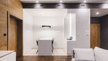 Een modern interieur met een eethoek, een bank en een wand van hout.