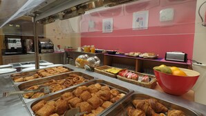 Un bufé con diversos alimentos, incluyendo pasteles y frutas.