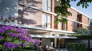 Un edificio moderno de dos pisos con ventanas amplias y un balcón.